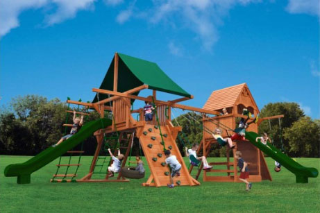 Turbo Deluxe Dual Swing-O-Saurus (38A) playset: Large wooden structure with two slides, climbing wall, swings, and green canopy. Perfect for backyard fun!